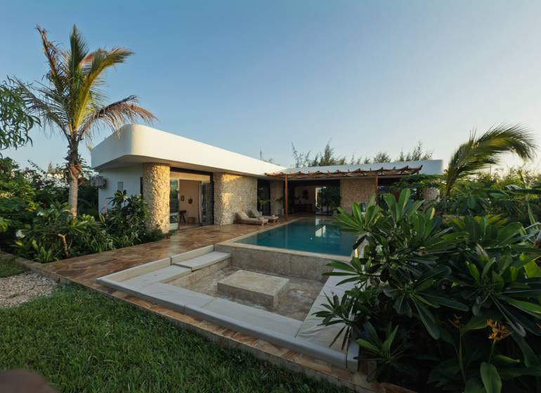 Családi ház Paje-ban, Unguja déli régiójában, medencével, buja növényzettel és burkolattal körülvéve.