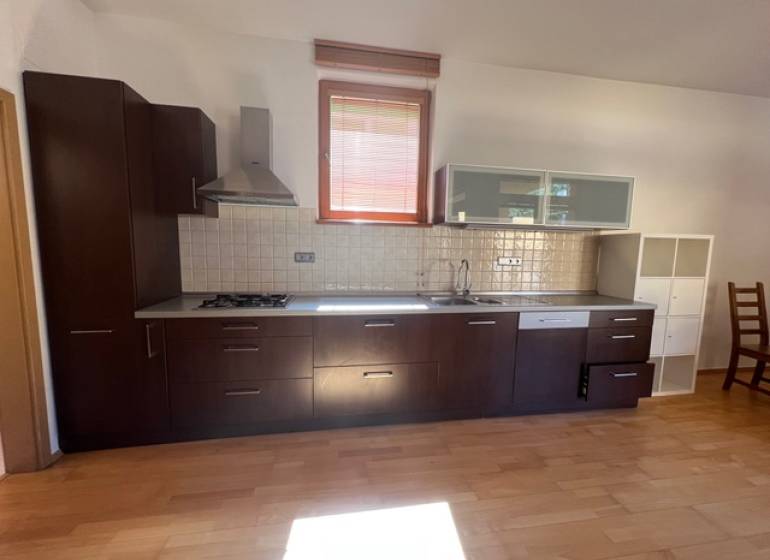 Konyha sötét szekrényekkel és készülékekkel a Moszkva utcai háromszobás lakásban.