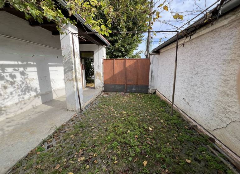 Egy családi ház udvara Jablonecben kőburkolattal és zöld növényzettel.