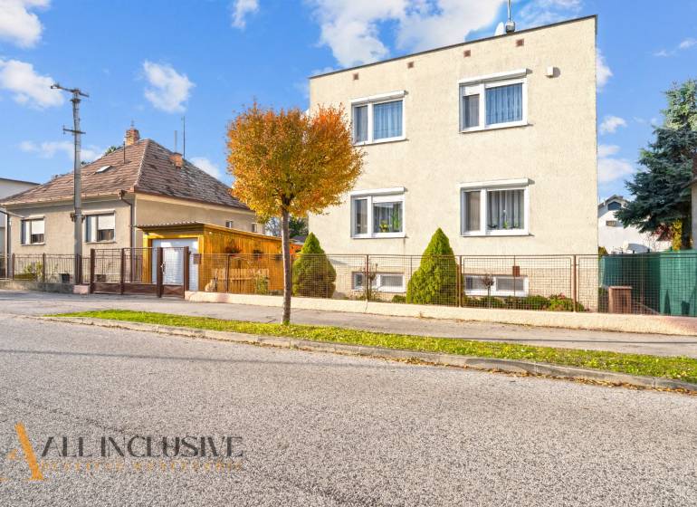 Családi házak Dunaszerdahelyen, fákkal szegélyezett utcák, rácsos kerítések, kék ég.