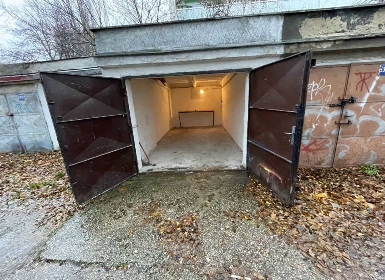 Nyitott garázsok a Priekopy utcában, Pozsony-Ružinovban, őszi levelekkel körülvéve.