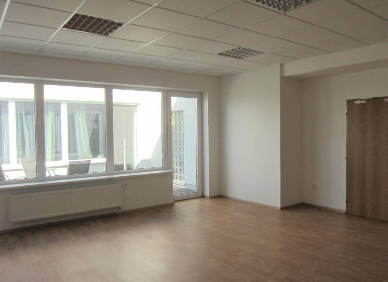 Tágas iroda nagy ablakokkal és fa dekorációjú padlóval.