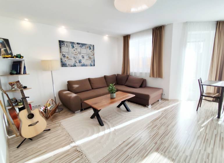 Nappali egy családi házban nagy kanapéval és fa dekorációjú padlóval.