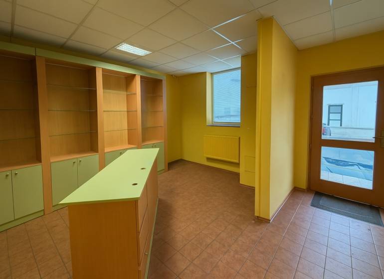 Kereskedelmi helyiségek polcokkal, pulttal és csempével, ideális különféle üzleti célokra.