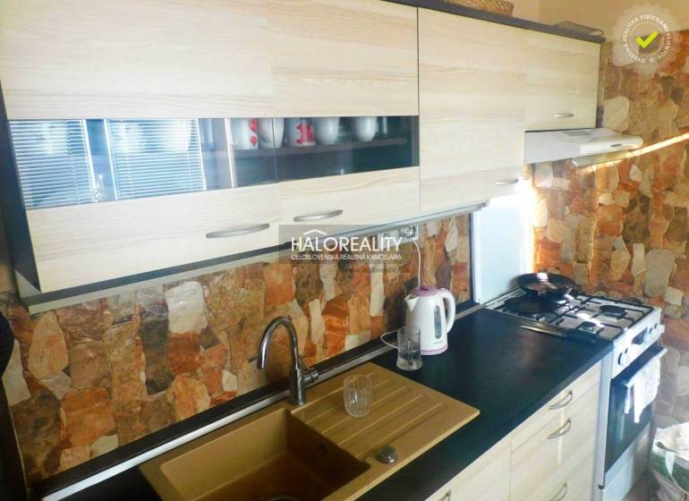 Szoba egy kétszobás lakásban fa dekoros padlóval, televízióval és beépített szekrényekkel.