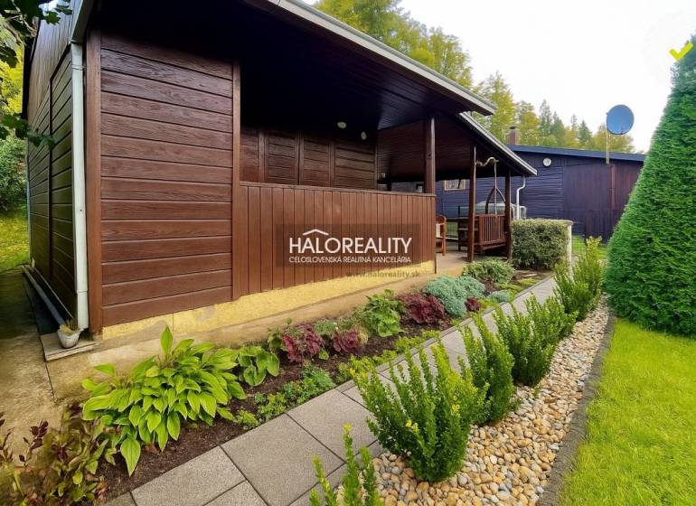 Faházikó a kertekben Bytča-ban, gondozott zölddel és járólapokból készült ösvénnyel körülvéve.