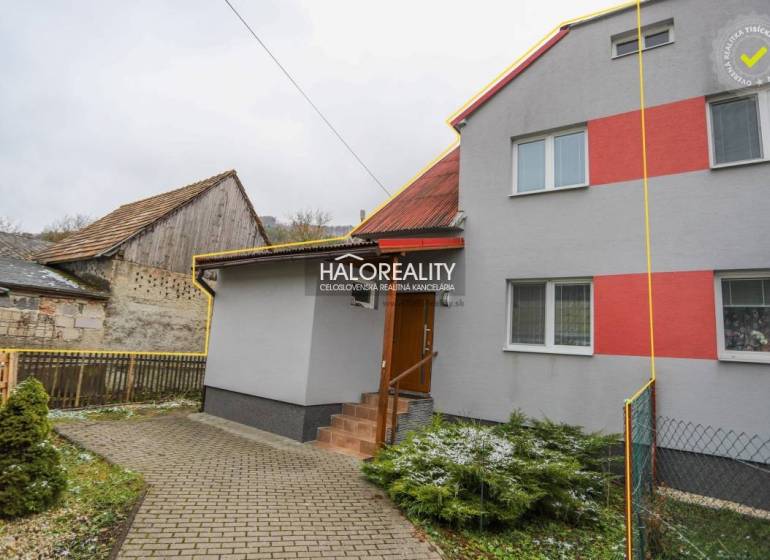 Családi ház Brvništeben piros és szürke színű homlokzattal, kert sétánnyal.