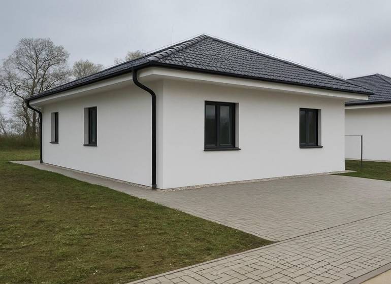 Családi ház Cíferen ferde tetővel és kövezett járdával.