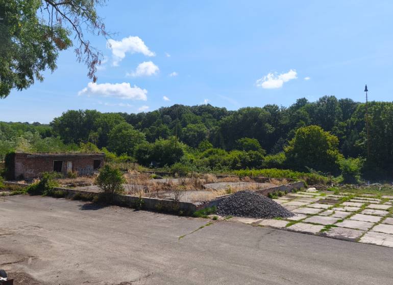 Kereskedelmi telkek a Nagykürtösi Losonci úton elhagyott épülettel, fákkal körülvéve.