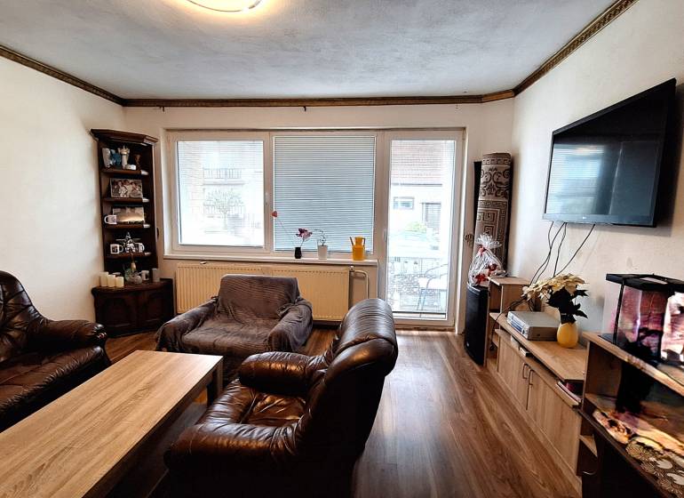 Nappali családi házban bőr bútorokkal és fa dekorációjú padlóval.