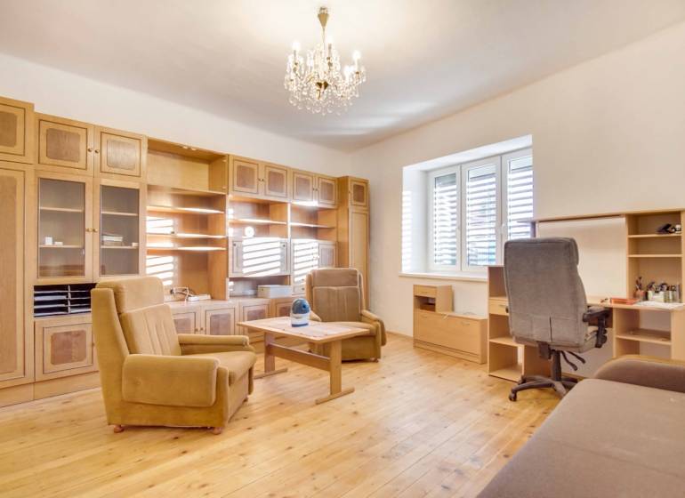 Családi ház belső tere bútorokkal, fa mintázatú padlóval és csillárral.