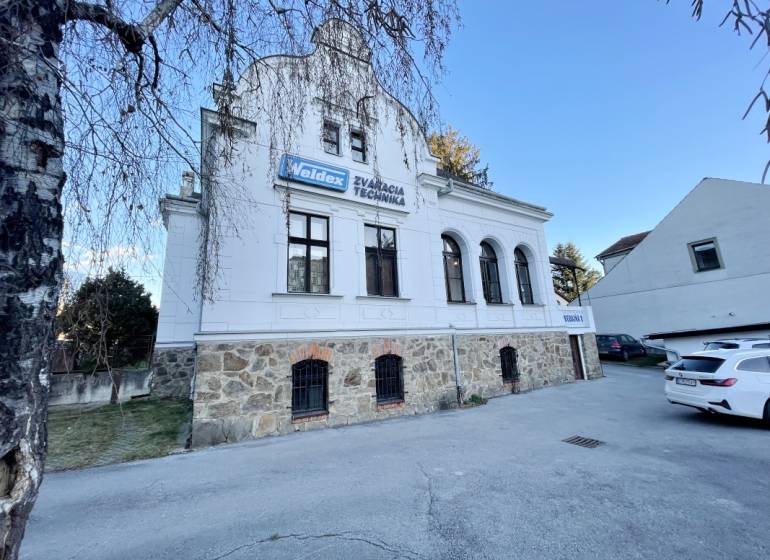 Egy épület a Vajanského utcában Eperjesen, kő földszinttel és fehér homlokzattal.