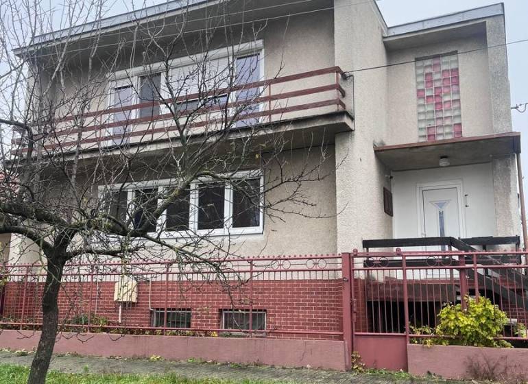 Családi ház Dlhá nad Váhom-ban beton homlokzattal, erkéllyel és előkerttel.