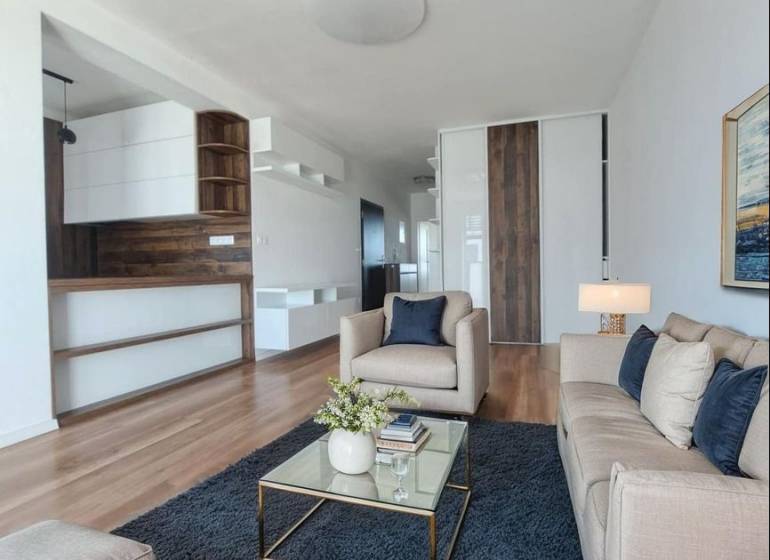 Nappali egy kétszobás lakásban, fa mintázatú padlóval és kényelmes kanapékkal.