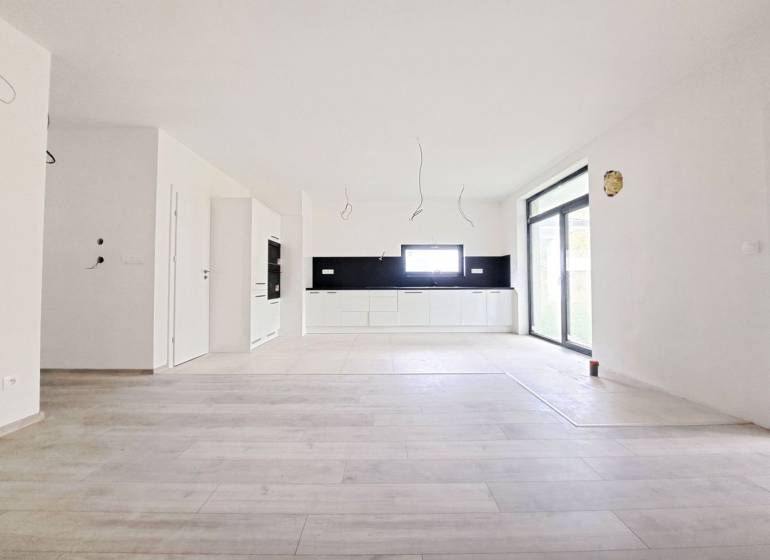 Tágas konyha fekete burkolattal és fa dekorációjú padlóval egy családi házban.