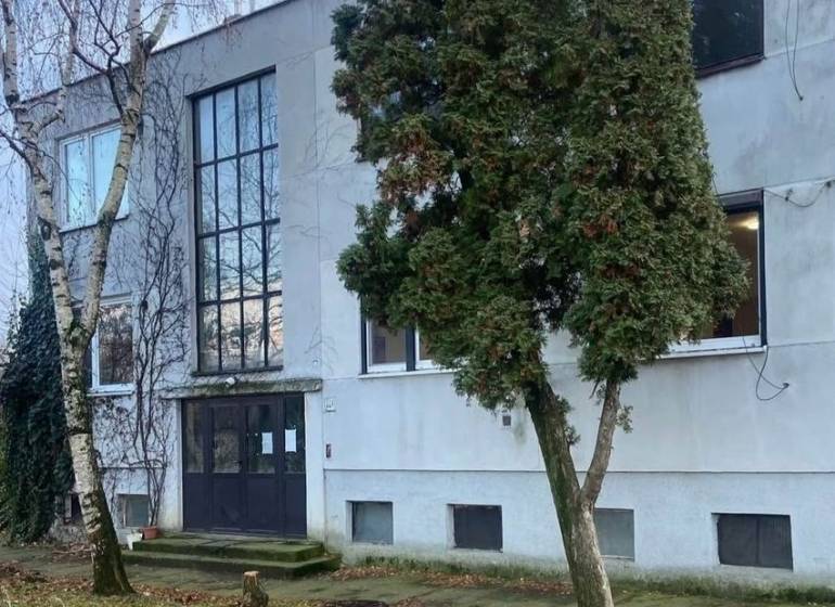 Az épület külseje Seliciach-ban, fákkal és füves környezettel körülvéve.