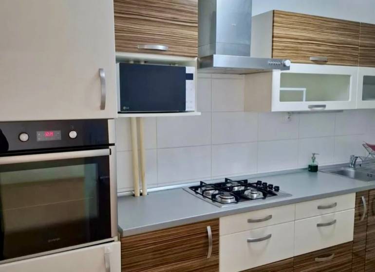 Konyha kőedény mosogatóval, főzőlappal és páraelszívóval egy 4 szobás lakásban.