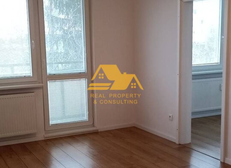 Világos, 2 szobás lakás fa hatású padlóval és nagy ablakokkal.