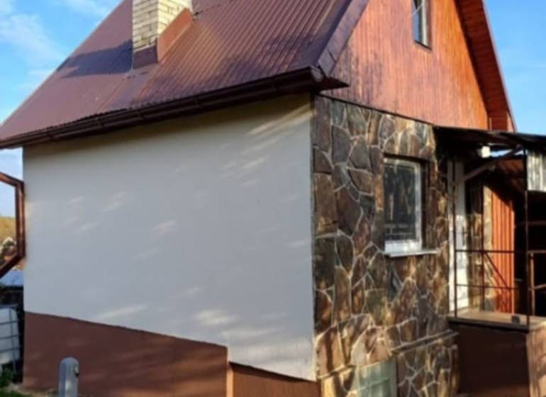 Pozdišovce-i ház kő homlokzattal és barna bádogtetővel.