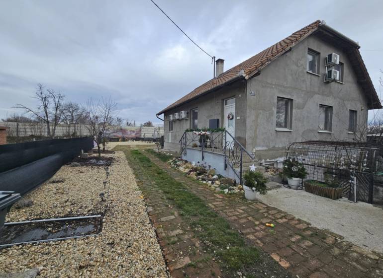 Családi ház Hernádkakon kerttel, kavicsos felhajtóval és fa elemekkel.