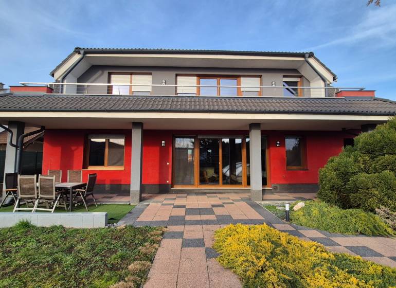 Családi ház Krakkóváron a Szeles utcában, piros homlokzattal és kerttel.