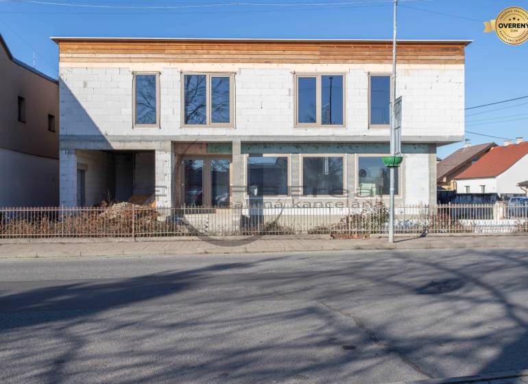 Egy befejezetlen homlokzatú épület Nagylévárdon, az út mellett áll.