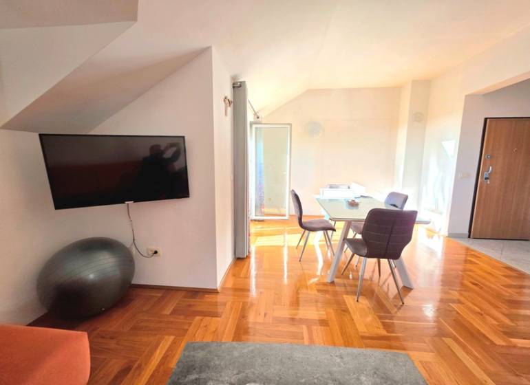 Egy nyaraló apartman belső tere fa dekor padlóval és étkezőasztallal.