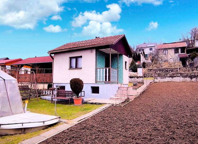 Házikó Partizánske közelében egyszerű kerttel, szegélyekkel és pavilonnal a kék ég alatt.