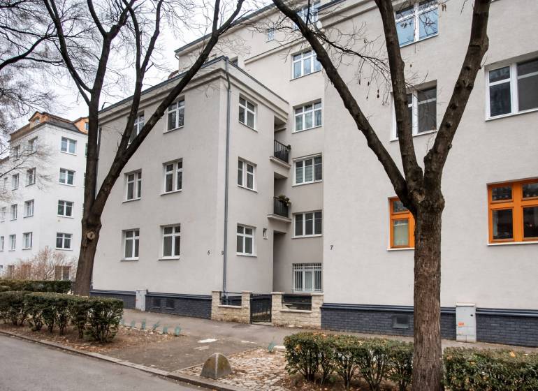 Lakóház Pozsonyban a Jurajov dvoron, Pri starej prachárni. Négyemeletes épület, fák, járda.