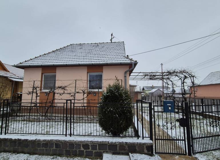 Családi ház az Új utcában, Nagy Ozorócban, havas tetővel és kerttel.