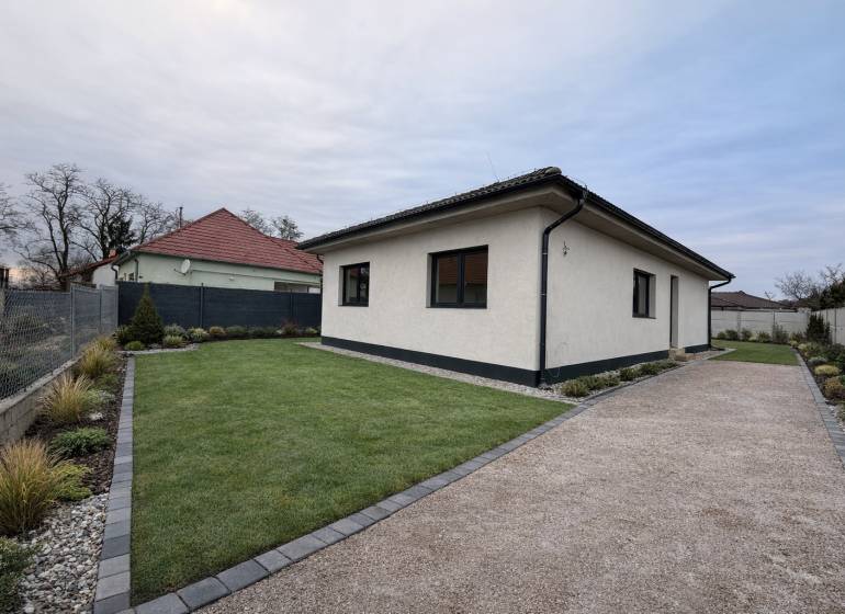 Családi ház Nagy-Grobban gyepesített udvarral, kavicsos járdával és rendezett kerttel.