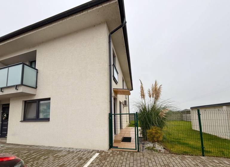 A Kráľovianky utcában található 3 szobás lakás külső része Kráľovianky városában, a bejáratnál növények és gyep.