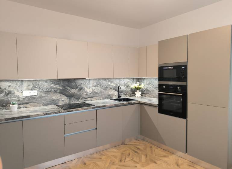 Konyha egy 4 szobás lakásban márvány munkalappal és fa dekor padlóval.