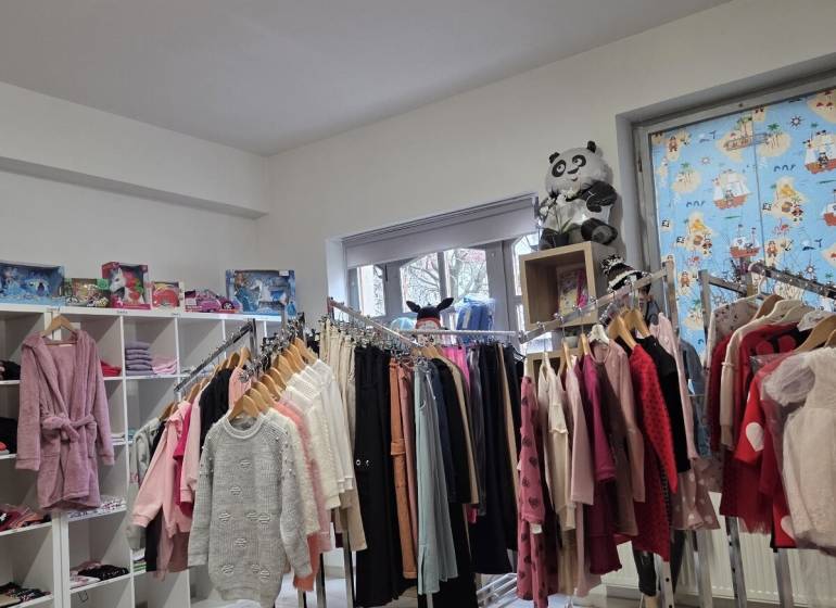 Üzlet ruházattal és játékokkal, állványokkal és polcokkal a Különleges ingatlanokban.