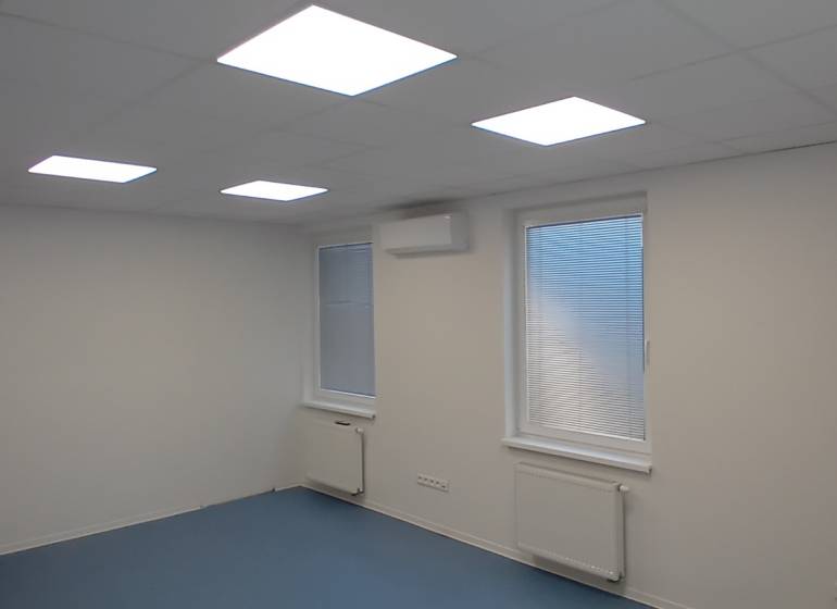 Irodák fehér mennyezettel, kék padlóval és redőnyös ablakokkal.