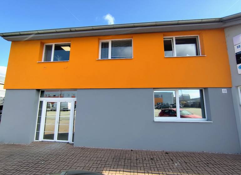 Az épület a Nyitrai Štúrova utcán, világos homlokzatú üzlethelyiségek.