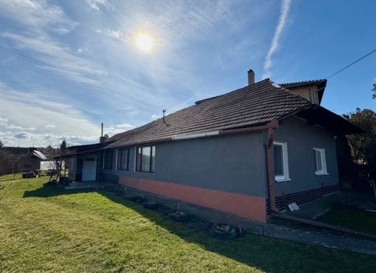 Családi ház Mýtné Ludanyban füves kerttel és téglafalú homlokzattal.