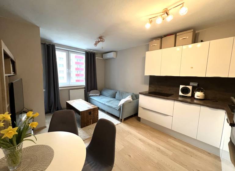 Konyha és nappali egy kétszobás lakásban fa dekor padlóval.