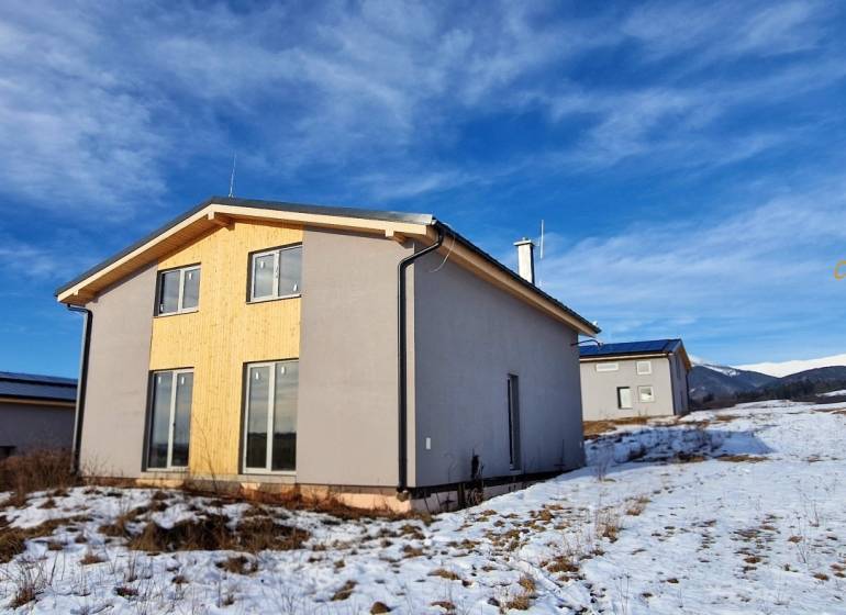 Ház Dolná Lehota-ban fa burkolattal, havas táj és hegyek a láthatáron.