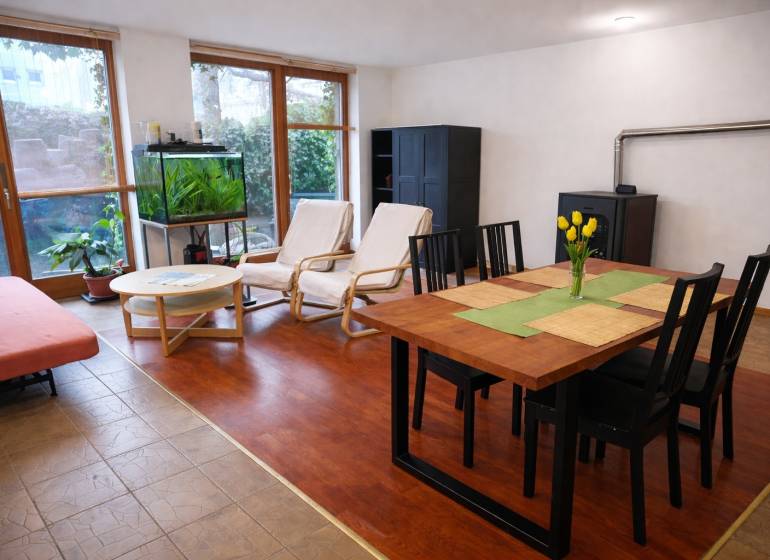 Nappali egy háromszobás lakásban, fa dekoros padlóval, étkezőasztallal és akváriummal.