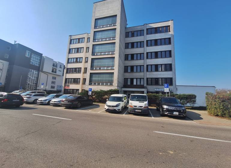 Irodaház a Tulská utcában, Zvolen városában, parkolóval és parkoló autókkal.