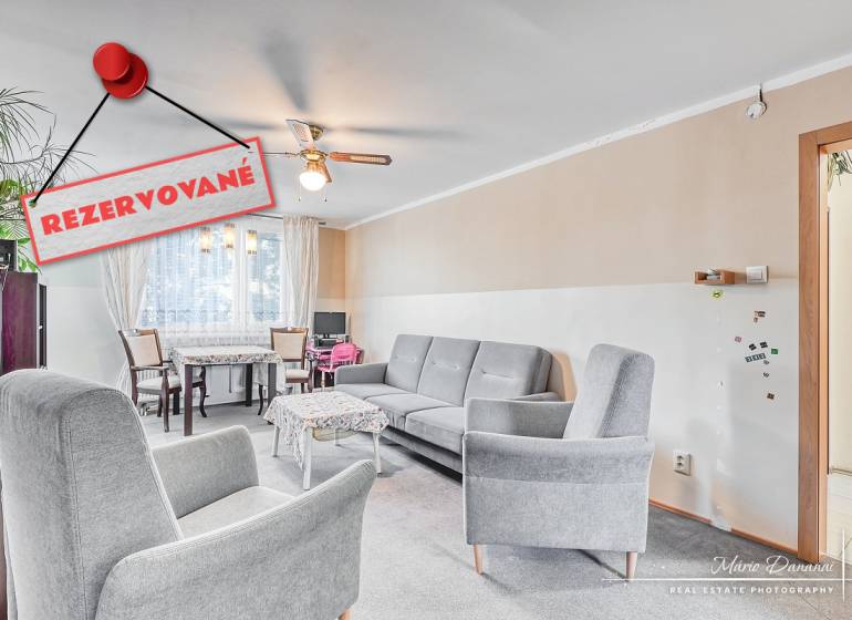 Nappali egy 4 szobás lakásban kényelmes fotelekkel és étkező sarokkal.