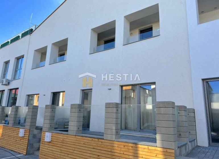 Új építésű ház több erkéllyel és 2 szobás lakással, betonkerítéssel és terasszal.
