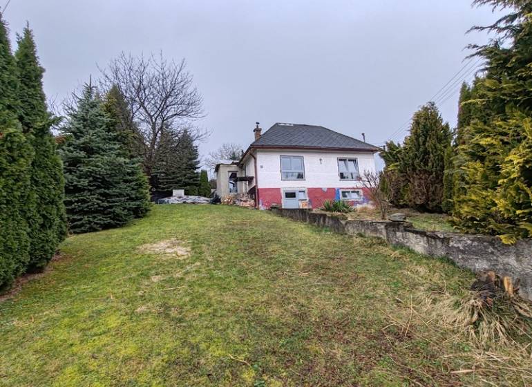 Családi ház a Fő utcán, Piskorócon, fákkal körülvéve és füves udvarral.