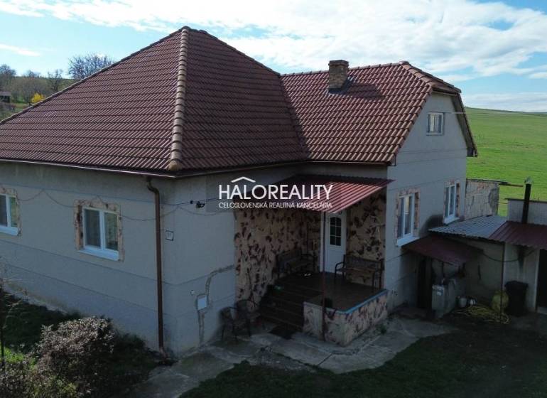 Családi ház Rimajánosiban piros tetővel és vidéki környezettel.