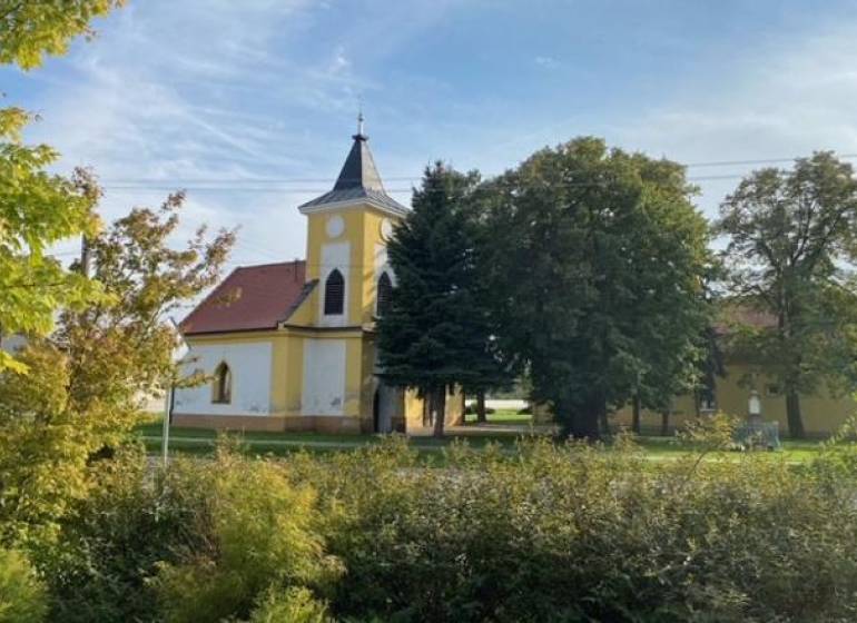 Egy templom zölddel körülvéve Práznovce mezőgazdasági és erdészeti területein.