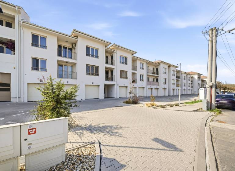 4 szobás lakás Dunaszerdahelyen világos homlokzattal és garázsokkal.