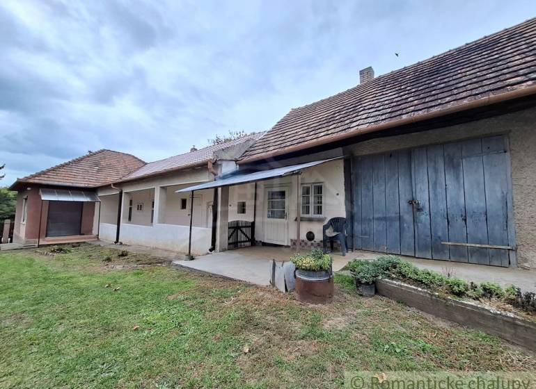 Családi ház Muzslán hagyományos homlokzattal, verandával és buja kerttel.