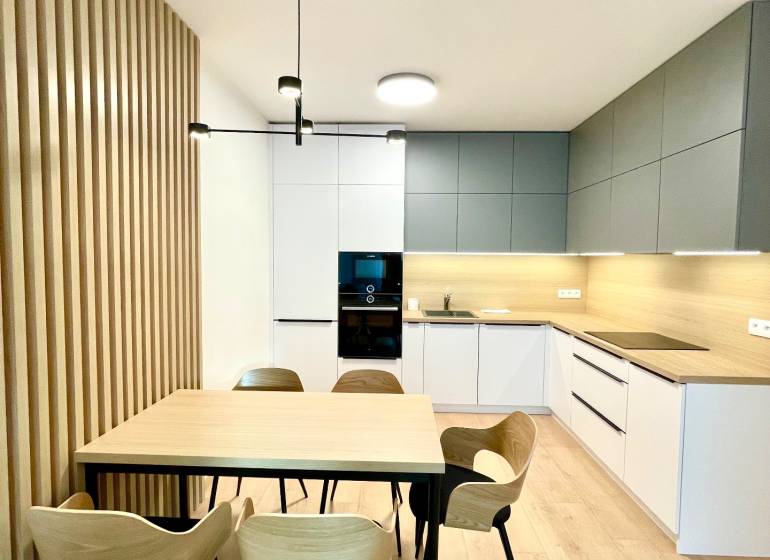 Konyha egy kétszobás lakásban fa dekoros padlóval és étkezőasztallal.