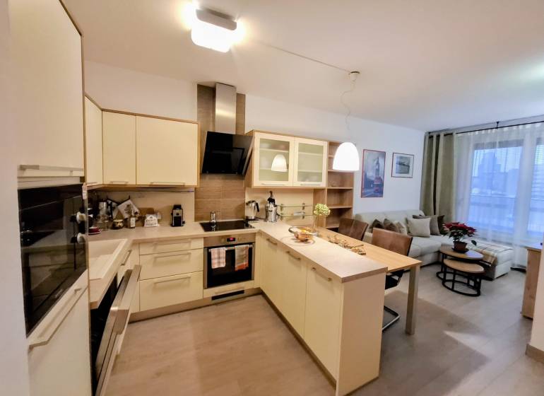 Konyha egy kétszobás lakásban konyhaszigettel és beépített készülékekkel.